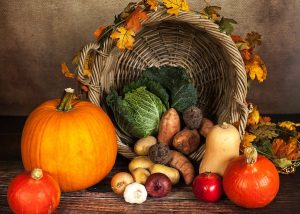 Cesta de calabazas y frutas otoñales