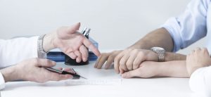 Dos personas dándose la mano en una mesa de reunión