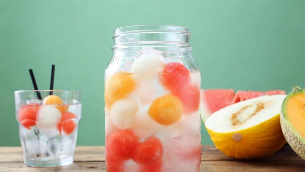 Vaso y jarra con frutas y bebida saludable