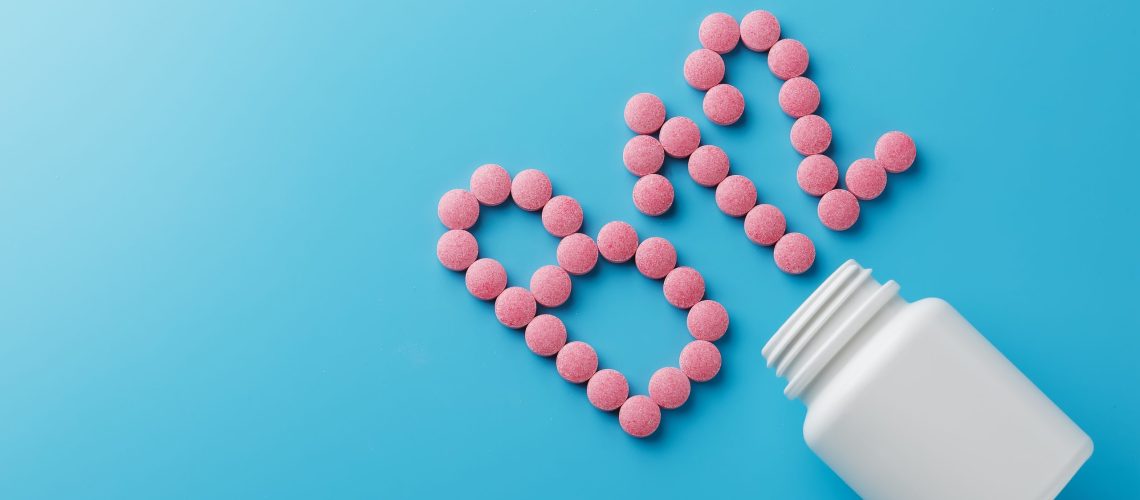 Cápsulas de vitamina B12 sobre fondo azul