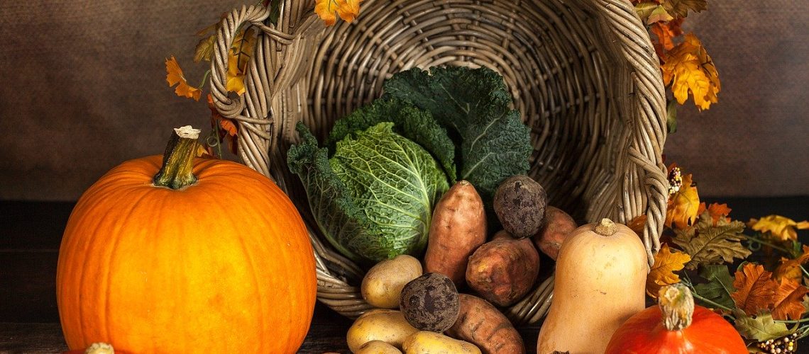 Cesta de calabazas y frutas otoñales