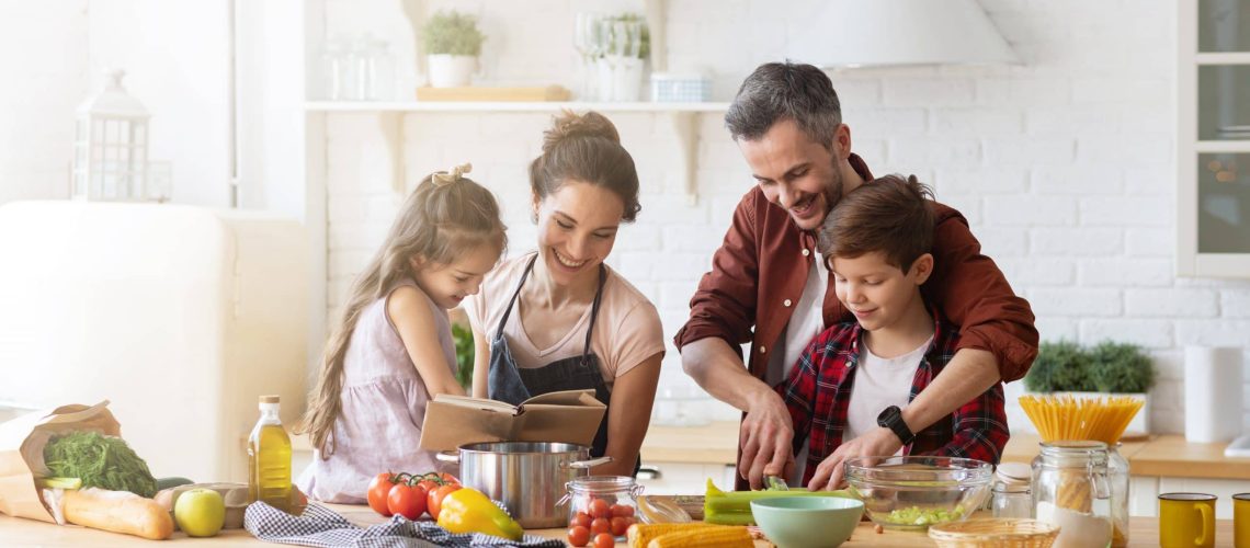 Familia cocinando alimentos saludables en la cocina