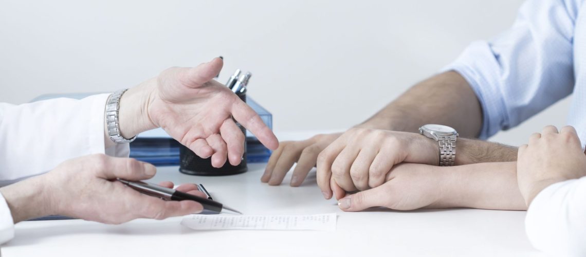Dos personas dándose la mano en una mesa de reunión